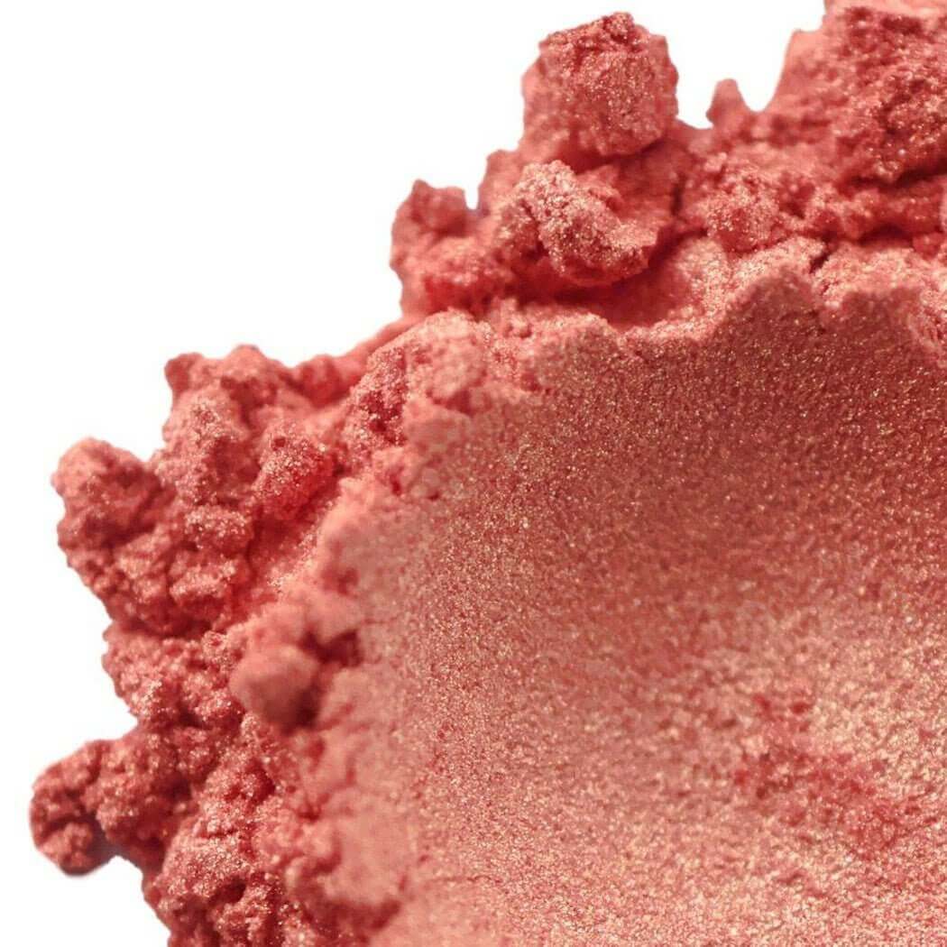 Close-up of Nurture Handmade coral blush powder with a shimmering finish.