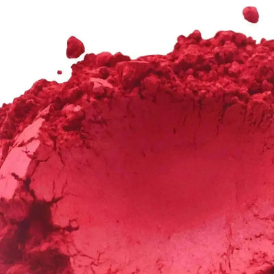 Heaped bright crimson red mica pigment on white background