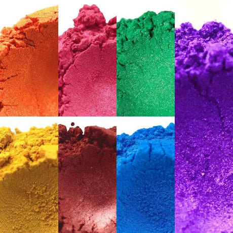 Bright powdered pigments in various colors including orange, red, green, purple, yellow, blue, and dark burgundy, used for handmade creations. Nurture Handmade.