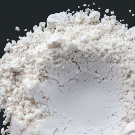 Close-up of white flour powder for Nurture Handmade baking ingredients against a dark background