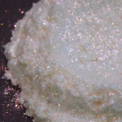 White glitter with pink and blue iridescent flecks on dark background